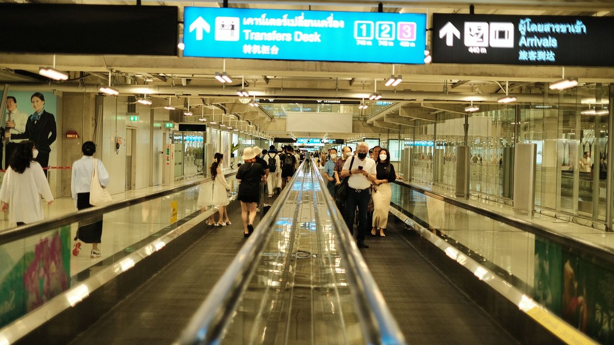Traveller using a smartphone in an Asian airport arrivals hall