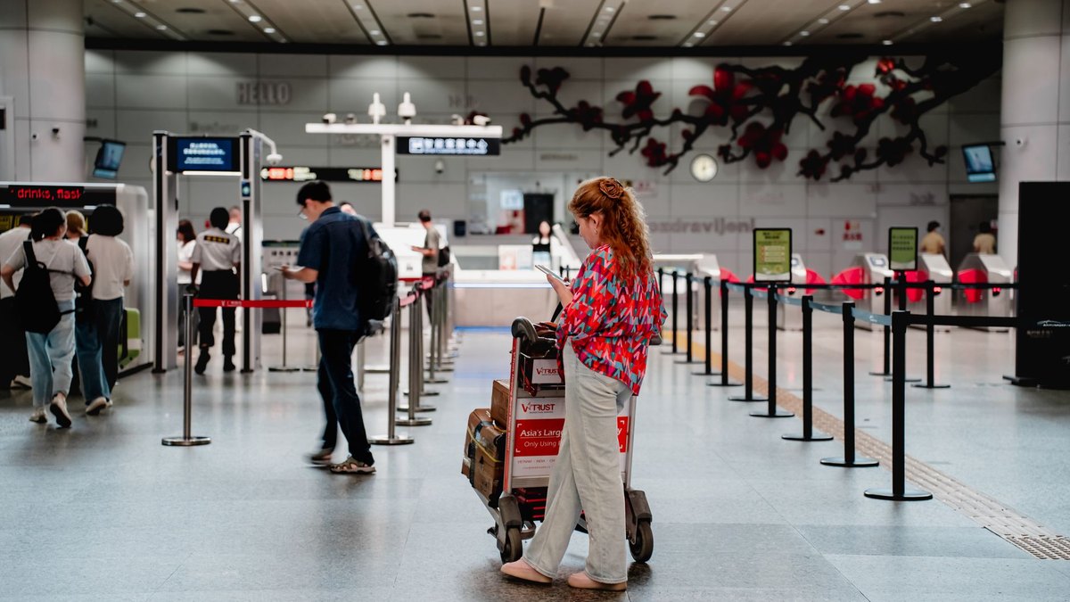 Traveller checking flight fares on a phone, the moment MakeMyTrip's Price Drop Protection now covers