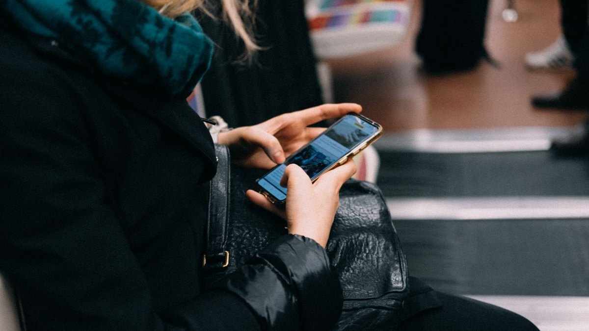 Traveller using a smartphone voice assistant to plan a trip at an Indian railway station