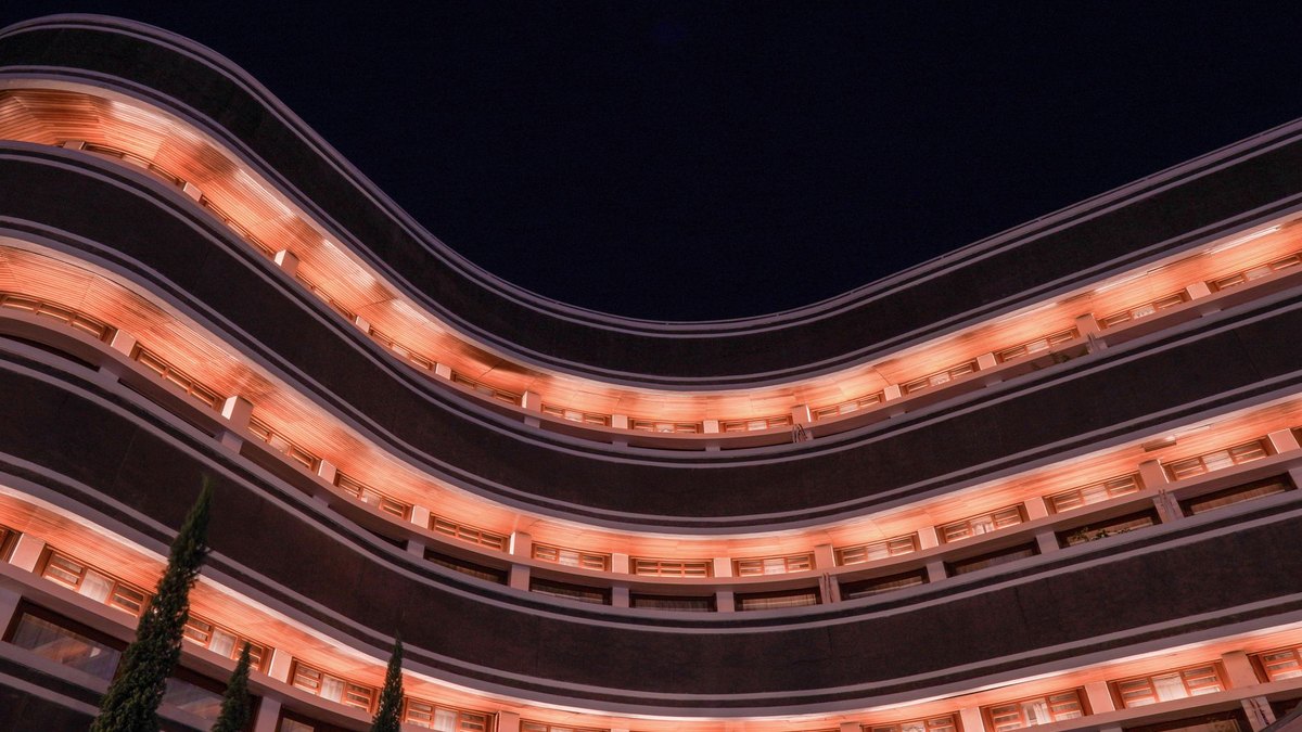 Exterior of a large modern hotel building in Madrid at dusk