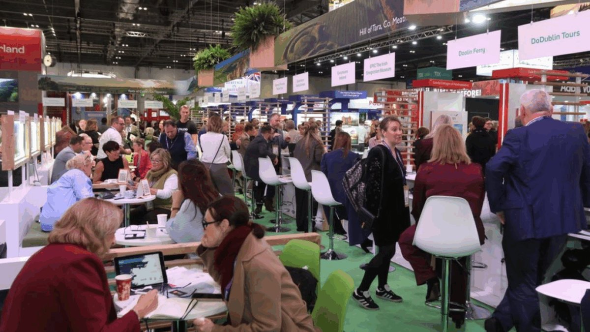 Visitors meeting at technology stands inside a large London exhibition hall