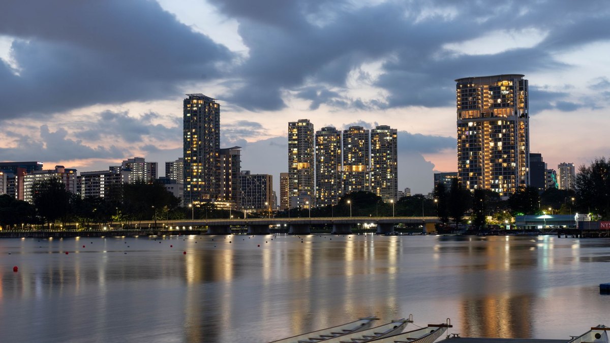 Singapore's Marina Bay skyline at dusk with travellers on the waterfront
